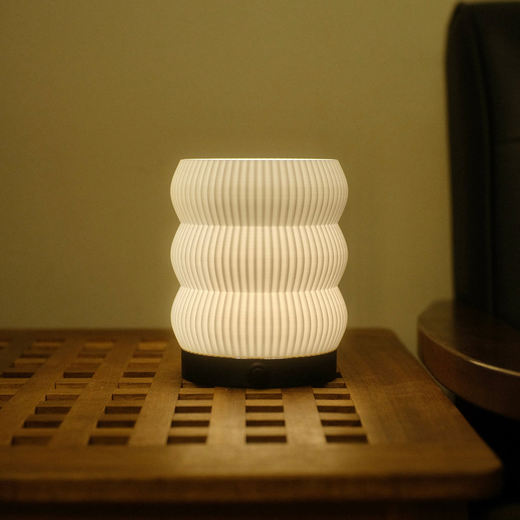 White textured lamp on a wooden surface with a neutral background