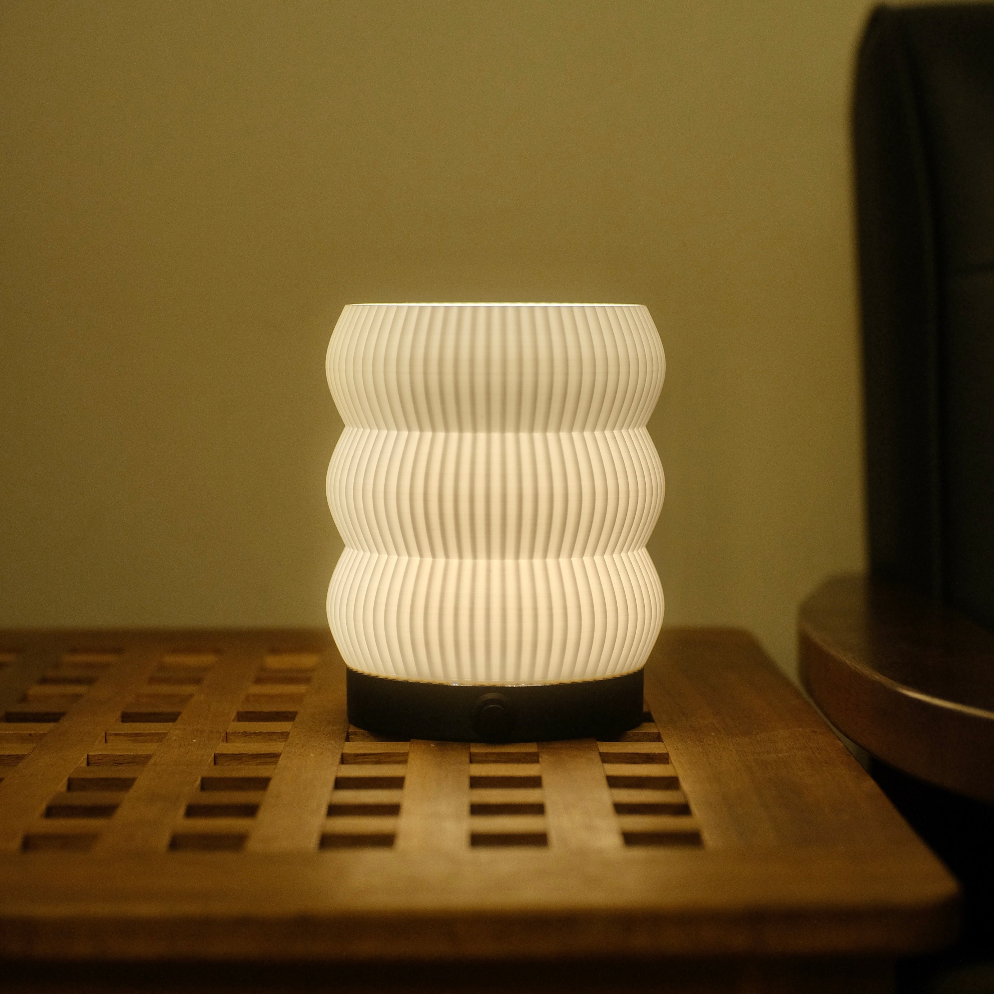 White textured lamp on a wooden surface with a neutral background